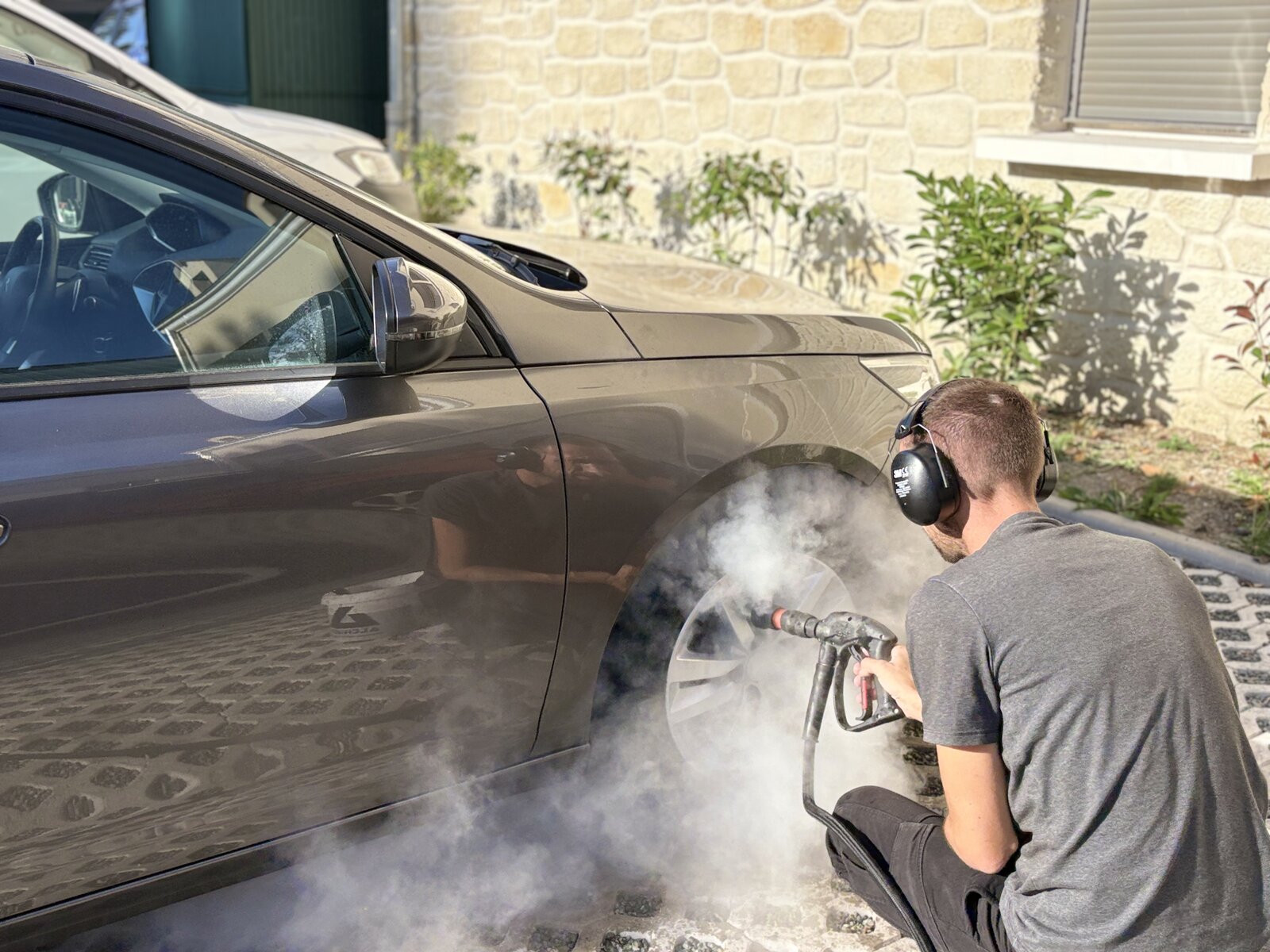 Technicien nettoyant une jante à la vapeur haute pression