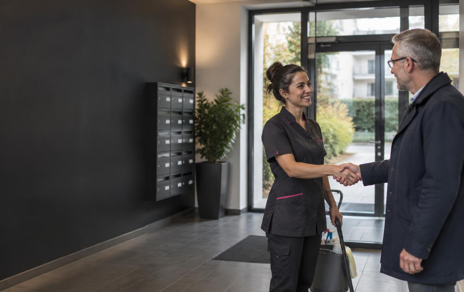 Une professionnelle Abn Facility échange avec un gestionnaire dans un hall de résidence